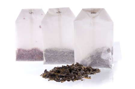 Three teabags with dry tea and heap of black tea. Focus on a first teabag.の写真素材