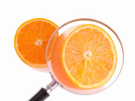 Juicy orange slice through magnifying glass. Shallow depth of fields, focus on orance in loupe.の写真素材