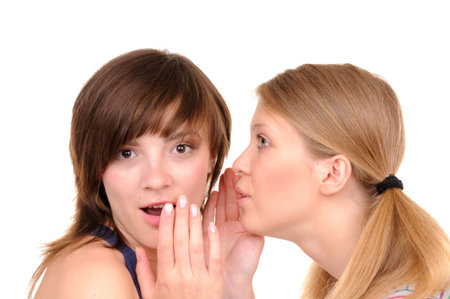 One young woman tell surprise news to another girl on white background