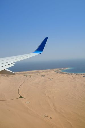 Airplane's wing under Egyptian desert and red sea coast with hotelsの写真素材