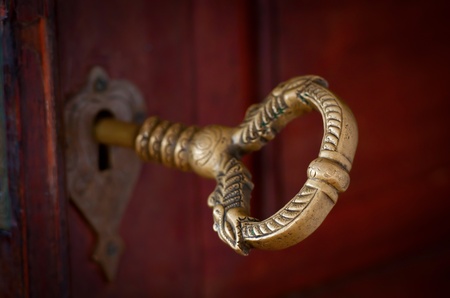 Antique beautiful bronze key in a doorの写真素材
