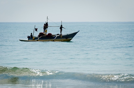 Mirissa, Sri Lanka - December 12, 2011: Traditional Asian small motorboat with four fishermen and fishing netのeditorial素材