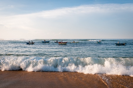 Morning fishing on traditional small wooden boats, Sri Lanka. Focus on the wave on front.の写真素材