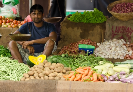 Bentota, Sri Lanka - December 14, 2011:  Asian man sell fresh vegetable and fruits on traditional asian open marketのeditorial素材