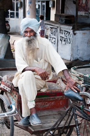 Amritsar, India - August 26, 2011: Rickshaw is a traditional asian taxi. Senior rickshaw is sitting on his cycleのeditorial素材