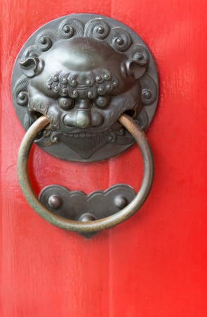 Old red chinese door with decorative metal handle, selective focus on the face frontの写真素材