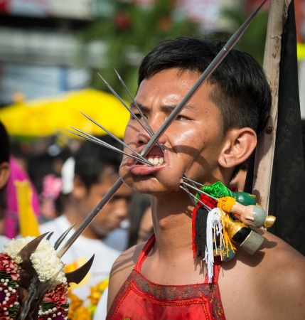 Phuket, Thailand - October 21, 2012: Devotee of Vegetarian Festival is Mah song, person who invites the spirits of gods to possess their bodies.  Mah song wearing elaborate costumes and pierce their cheeks and tongues with all manner of things.のeditorial素材
