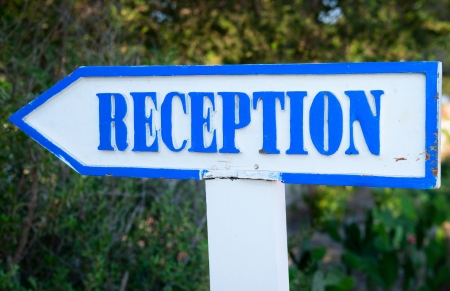 Wooden vintage index to a hotel reception with green plants on backgroundの写真素材