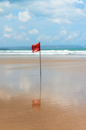 Red flag on beach with no swimming notes  Season of storms and strong currents の写真素材
