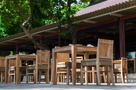 Outdoor restaurant with wooden chairs and tablesの写真素材