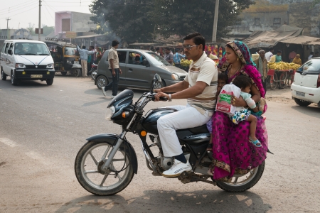AGRA, INDIA - NOVEMBER 15: Indian family with two kids on motorcycle on typical messy street in central India on Nov 15, 2012 in Agra, Indiaのeditorial素材
