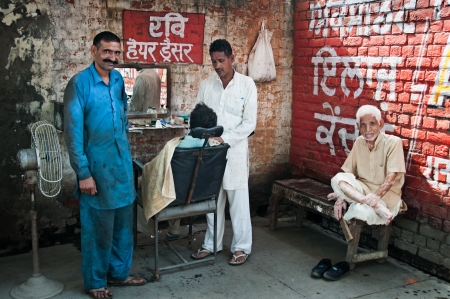 AMRITSAR, INDIA - AUG 28: Barber shaving a man in the street mobile barberのeditorial素材