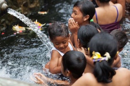 TIRTA EMPUL, INDONESIA - SEP 21: Bali prayers take a bath  in the sacred holy spring water on Sep 21, 2012 in Tirta Empul, Bali, Indonesia. It is famous place for purification of Bali peopleのeditorial素材