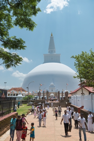 ANURANHAPURA, SRI LANKA - APR 16: Pilgrims pass central entrance to white sacred stupa Ruwanmalisaya dagoba on Apr 16, 2013 in Anuradhapura, Sri Lankaのeditorial素材