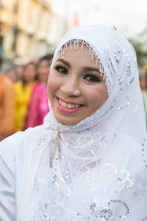 PHUKET, THAILAND - 07 FEB 2014: Beautiful woman in white muslim headscarf take part in procession parade of annual old Phuket town festival. のeditorial素材