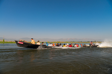 INLE LAKE, MYANMAR (Burma) - 07 JAN 2014: People transportation wooden long boat with motor fast move on blue water. Boats is a key transport type on Inle lake. のeditorial素材