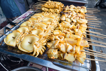 Heap of barbecue squids on grill brazier stove for saleの写真素材