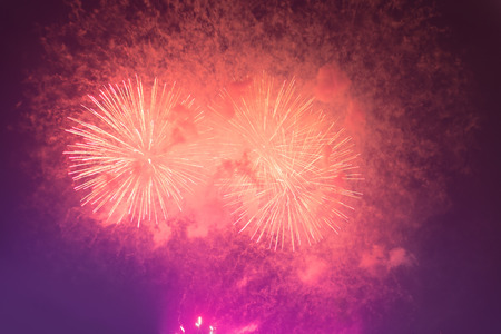 Fireworks in night dark sky with smoke after explosionsの写真素材