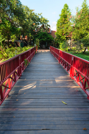 Wooden bridge with red fence  in green tropical park の写真素材