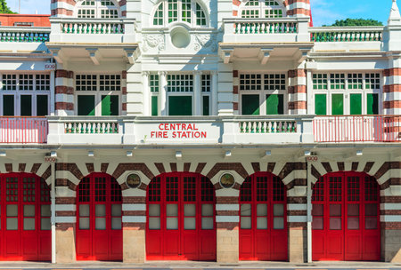 Vintage retro fire station building facade with red gates and brick walls
