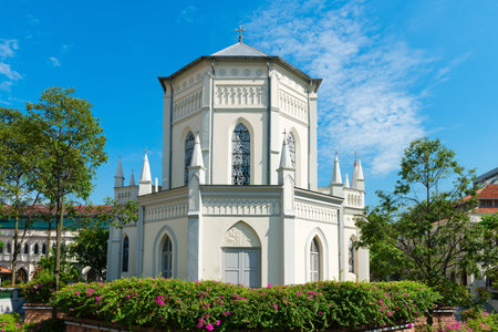 Old church building in neoclassical style with stained-glass window under blue sky.の写真素材