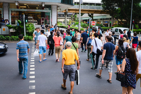 SINGAPORE - 01 JAN 2014: People on pedestrians crossing on famous street Orchard Road in Singapore. Orchard Road is the most popular shopping enclave of Singapore and major tourist attraction.のeditorial素材