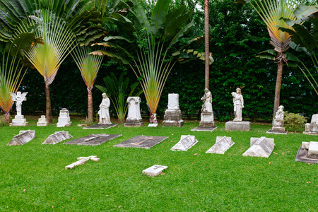 Stone gravestones statues and crosses on old classical in cemetery in green tropical parkのeditorial素材