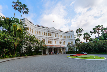 SINGAPORE - 07 AUG 2015: Grand facade of the luxurious Raffles Hotel in downtown Singapore, with its beautiful gardens.のeditorial素材