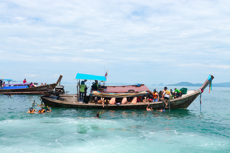 KRABI, THAILAND - 12 OCT 2014: Many tourists snorkeling off long boats in the clear cool tropical ocean near Krabi, Thailandのeditorial素材