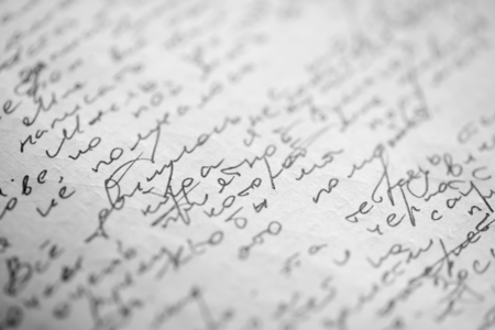 Hastily scrawled handwriting of cyrillic text using black ink on white paper, with visible imprints from writing on the obverse.の写真素材