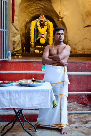 KUALA LUMPUR, MALAYSIA - 22 MAR 2017: Hindu priests in Batu caves temple with the God statue on background.のeditorial素材
