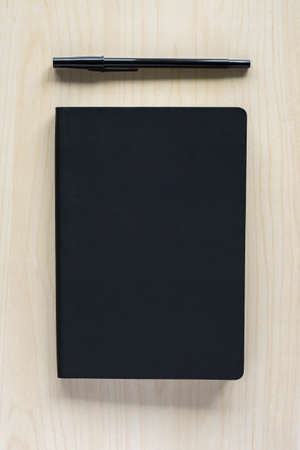 Black notebook and pen on table