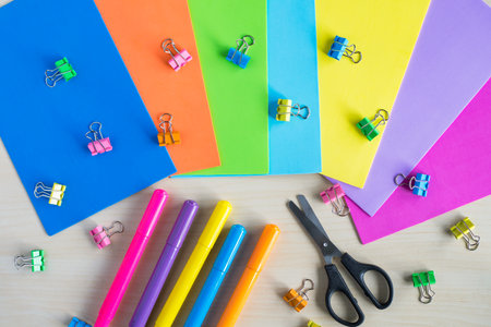 Bright children craft supplies on table. Foam colorful sheets, binder clips, markers and scissors on wooden desk.の写真素材