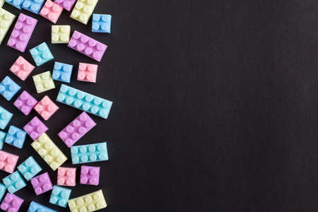 Building blocks on black background with empty space on one sideの写真素材