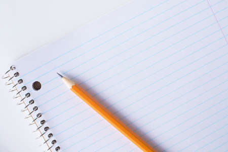 Striped blank notebook and pencil. Spiral notepad and orange pencil.