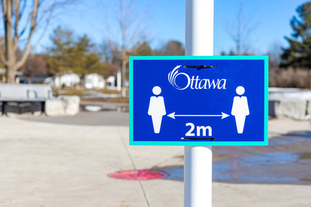 Ottawa, Canada - March 20, 2021: physical distance of 2 m between people blue sign in park in early spring during corona virus pandemicのeditorial素材