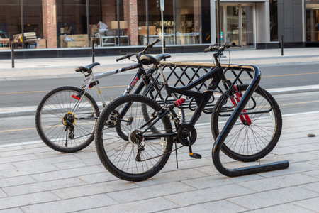 Ottawa, Canada May 23, 2021: Bike rack for parking bicycles in the street of downtown. Bycycle stand with locked vehicles on pavement near road in the city.のeditorial素材