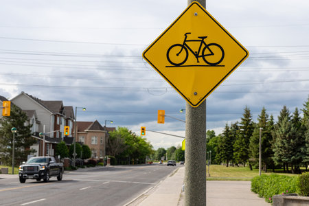 Canada, Ottawa - May 26, 2021: Yellow traffic road sign warning cyclist on bicycle crossing the roadのeditorial素材