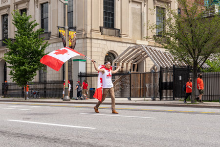 Ottawa, Canada - July 1, 2021: Canada day in Ottawa Canada in downtown. Man waving canadian flags...