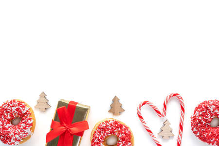 Christmas composition isolated on white background with copy space. Flat lay of gift box and candy canes in heart shape.の写真素材