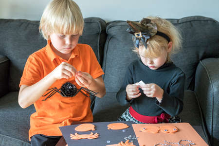 Halloween kids craft preparations. Little children doing crafts at home. Halloween family party concept.の写真素材