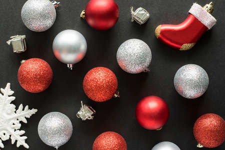 Christmas flat lay on black background. New year concept. Top view of red and silver holiday decorations on dark.の写真素材