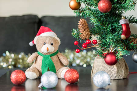 Christmas teddy bear, New Year decorations and small Christmas tree on the table. Holiday preparation at homeの写真素材