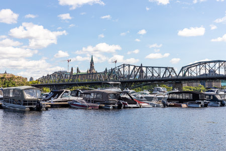 Ottawa, Canada - August 2, 2021: Alexandra Bridge between Gatineau city of Quebec to Ottawa, Ontario in Canada. Portage Champlain Yacht Club with boats and yachts on water and Parliamentのeditorial素材