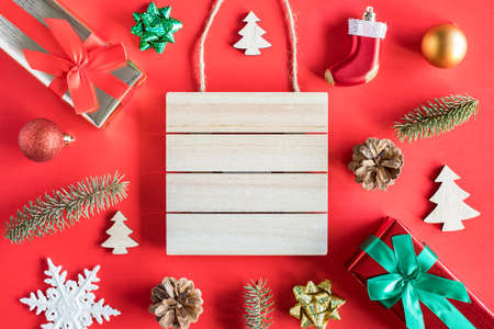 Wooden sign board frame and christmas tree decorations on red background. Christmas holiday concept with copy space for text.の写真素材