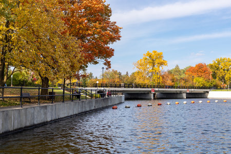 Ottawa, Canada - October 11, 2021: Rideau River with people walking along embankment and Hog's Back Bridge in autumn seasonのeditorial素材