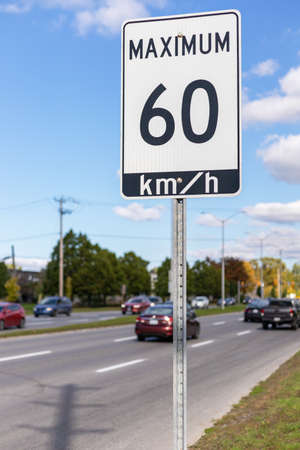 Speed limit road sign in the street, 60 km per hourh maximum in Ottawa city, Canada. City traffic on the road.の写真素材