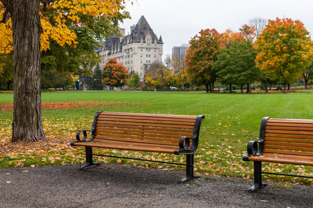 Ottawa, Canada - October 14, 2021: Major's Hill Park with benches in fall and Fairmont Chateau Laurier hotel in background in downtown of the city in autumn seasonのeditorial素材
