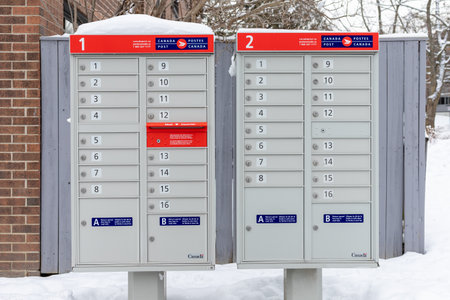 Ottawa, Canada - January 17, 2021: Canada Post mailbox with red sign in English and French near house in winter seasonのeditorial素材