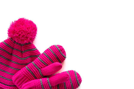 Set of pink knitted hat and mittens for child isolated on white background with copy space. Children winter clothes. Accessories for girlsの写真素材
